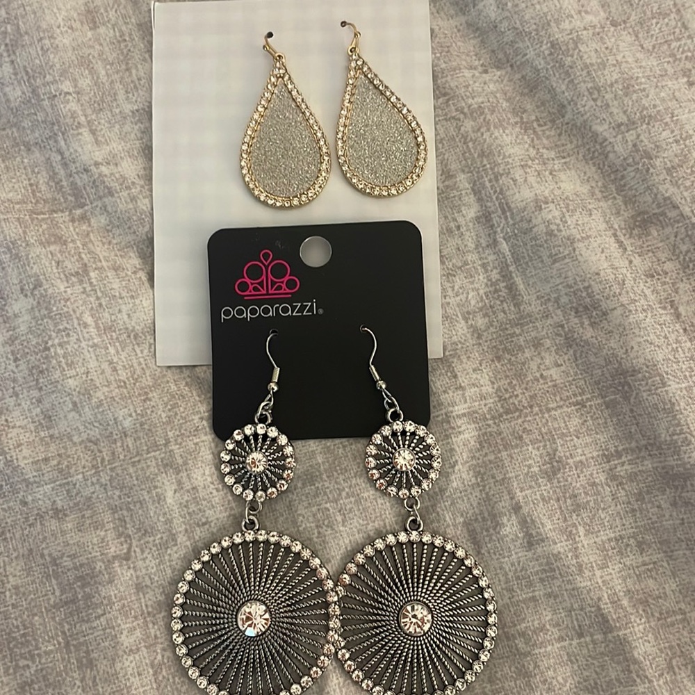 A set of two pairs of earrings, one silver one gold.